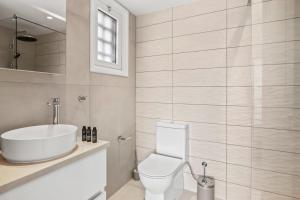 Un baño blanco con lavabo e inodoro. en Golden Hour Villa by Nomads, en Tala 17 fotos más