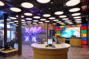 un museo con un dinosaurio y dos pantallas grandes en NYX Hotel Edinburgh, en Edimburgo