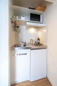 a small kitchen with a sink and a white refrigerator at Boucicaut Yellow Studio in Chalon-sur-Saône