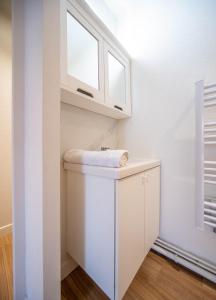 a small kitchen with white cabinets and a window at Boucicaut Yellow Studio in Chalon-sur-Saône