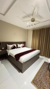 une chambre avec un grand lit avec un plafond dans l'établissement Marigold hotel and restaurant, à Sialkot