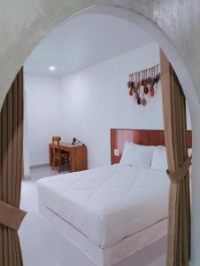 Un dormitorio con una cama blanca y una mesa. en Dragonfly, en Nusa Penida 50 fotos más