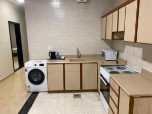 eine Küche mit Waschmaschine und Spüle in der Unterkunft منازل الخليج للشقق الفندقية in Dammam + 7 Fotos