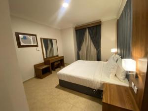 ein Hotelzimmer mit einem Bett und einem Spiegel in der Unterkunft منازل الخليج للشقق الفندقية in Dammam
