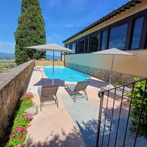 a swimming pool with two chairs and two umbrellas at TUSCANFLAT Castle in Scrofiano