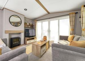 ein Wohnzimmer mit Sofa und Fernseher in der Unterkunft Burtree Lakes Holiday Park in Bedale