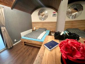 a room with a bed and a table with a book at ESZLA 1 Apartman Free large secure parking in Debrecen