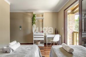 a bedroom with two beds and a desk in it at Vieira Eco Inn – Deluxe Suite Thiago #3 in Orleans