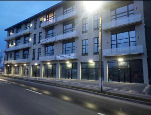 a large white building on the side of a street at Royal Loft Residence in Târgu Jiu