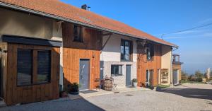 a house with wooden doors on the side of it at Domaine de la Griffe - Appartement "Sous Dine" in La Roche-sur-Foron