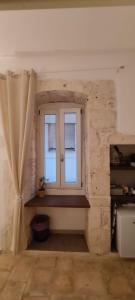 a room with a window and a stone wall at Dioniso Affittacamere in Conversano