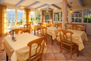 a restaurant with tables and chairs and windows at Die WUNDER s Ferienpension in Pörtschach am Wörthersee