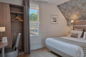 une chambre d'hôtel avec un lit et une fenêtre dans l'établissement The Originals City, Le Beaujoire, Nantes - En face du Parc des Expositions et face au Stade Beaujoire, à Nantes 33 autres photos