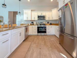 a kitchen with white cabinets and stainless steel appliances at Rainbow River Bungalow with Early Checkin! in Dunnellon