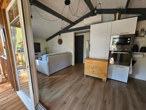 eine Küche und ein Wohnzimmer mit einem Kühlschrank und einem Sofa in der Unterkunft Chalet Bien-Etre du Domaine in La Hume