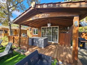 eine Holzterrasse mit Außenküche und Grill in der Unterkunft Chalet Bien-Etre du Domaine in La Hume