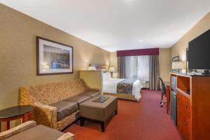 a hotel room with a couch and a bed at Best Western Plus Canyon Pines in Ogden