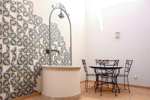 a kitchen with a sink and a table with chairs at Casa do Poço in Faro
