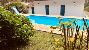 a swimming pool in front of a house at Recanto UAI in Piedade