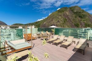 eine Terrasse mit Stühlen, Tischen und einem Berg in der Unterkunft Américas Copacabana Hotel in Rio de Janeiro