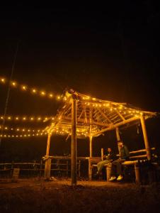 two people sitting under a gazebo with lights at Cloud Wayne in Ambalavayal