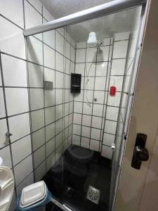 ein kleines Badezimmer mit Dusche und Toilette in der Unterkunft Bela Vista Condominio Village dos Pássaros in Guarapari