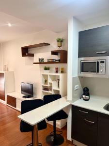 a kitchen with a table and chairs and a microwave at Vigo Center Rooms in Vigo