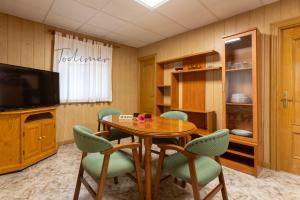 ein Esszimmer mit Tisch und Stühlen und einem Fernseher in der Unterkunft Todimer casa roble in Carchuna