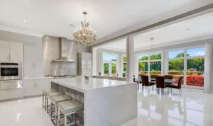 a large white kitchen with a large island with chairs at Luxury Estate for Filming in Gaithersburg