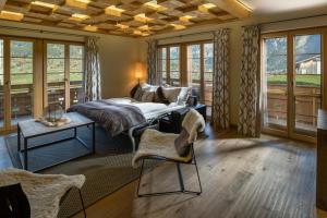 a bedroom with a bed and a table and windows at Aspen Alpine Lifestyle Hotel in Grindelwald +131 photos