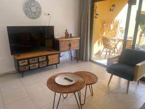 a living room with a tv and a chair and a table at Rony by Best Holidays Fuerteventura in Corralejo