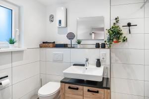 a white bathroom with a sink and a toilet at Tor zum Hochwald in Thomm +16 photos
