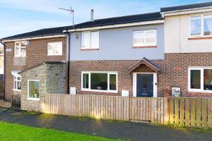 ein Backsteinhaus mit einem Holzzaun davor in der Unterkunft Durham WorkNest in Burnhope