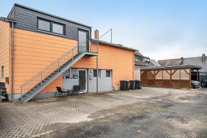 an orange building with a staircase on the side of it at Tor zum Hochwald in Thomm