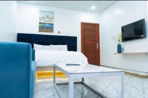 a bedroom with a bed and a table and a tv at Hotel Spintex and tours in Accra +3 photos
