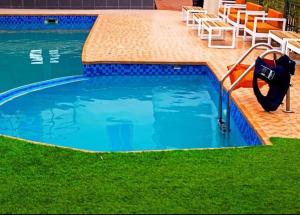 a large swimming pool with a hose in the grass at Hotel Spintex and tours in Accra
