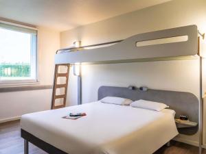 a bedroom with a bunk bed with a ladder at ibis budget Roissy CDG Paris Nord 2 in Roissy-en-France +49 photos