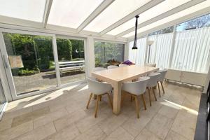 a dining room with a wooden table and chairs at Hello Zeeland - Margrietenlaan 5 in Oostkapelle +18 photos
