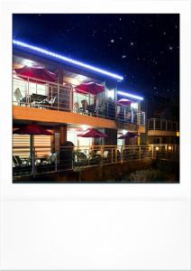 a building with tables and chairs and umbrellas at night at Four Seasons Pension in Suncheon