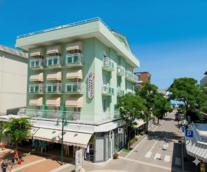 ein grünes Gebäude an der Ecke einer Straße in der Unterkunft Hotel Ferrara in Cattolica