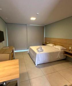 ein Hotelzimmer mit einem Bett und einem Schreibtisch und einem Bett sidx sidx sidx in der Unterkunft Villas BobZ - Ap Taiti 304 in Barrinha