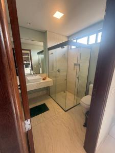 ein Badezimmer mit Dusche, Toilette und Waschbecken in der Unterkunft Villas BobZ - Ap Taiti 304 in Barrinha