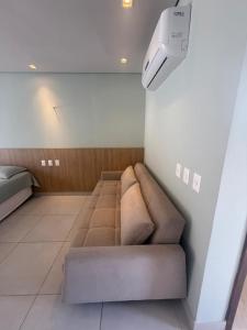 ein Wohnzimmer mit einem Sofa und einer Lampe in der Unterkunft Villas BobZ - Ap Taiti 304 in Barrinha