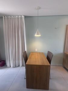 ein Esszimmer mit einem Holztisch und Stühlen in der Unterkunft Villas BobZ - Ap Taiti 304 in Barrinha