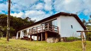a white house with a balcony on the side of it at Recanto UAI in Piedade