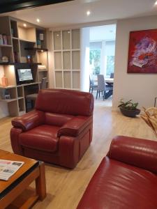 a living room with a leather couch and a table at Logis Hotel La Closerie in La Baule +43 photos