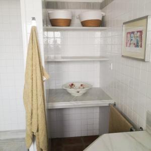 a bathroom with a towel and a bowl on a shelf at villa el almendro in Carratraca