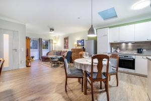 une cuisine et un salon avec une table et des chaises dans l'établissement Apartment On The Upper Floor, à Bokelrehm