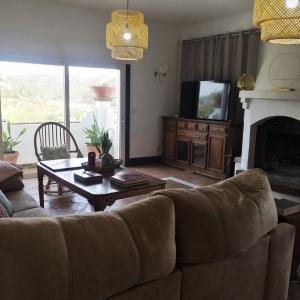 a living room with a couch and a table and a tv at villa el almendro in Carratraca