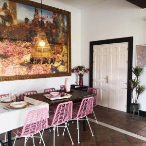 a dining room with a table and pink chairs at villa el almendro in Carratraca